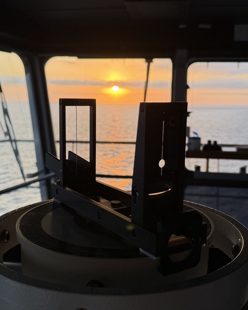 Bridge bearing instrument silhouetted against the sunset